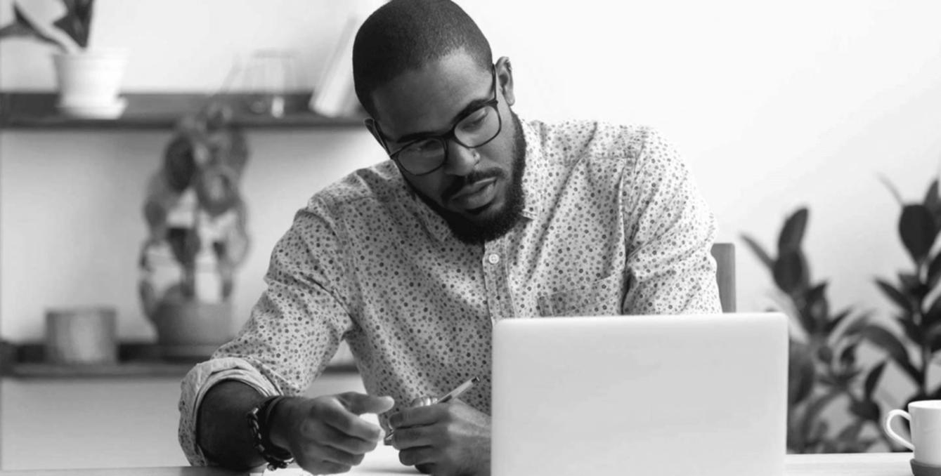 Person analysiert Finanzunterlagen am Schreibtisch